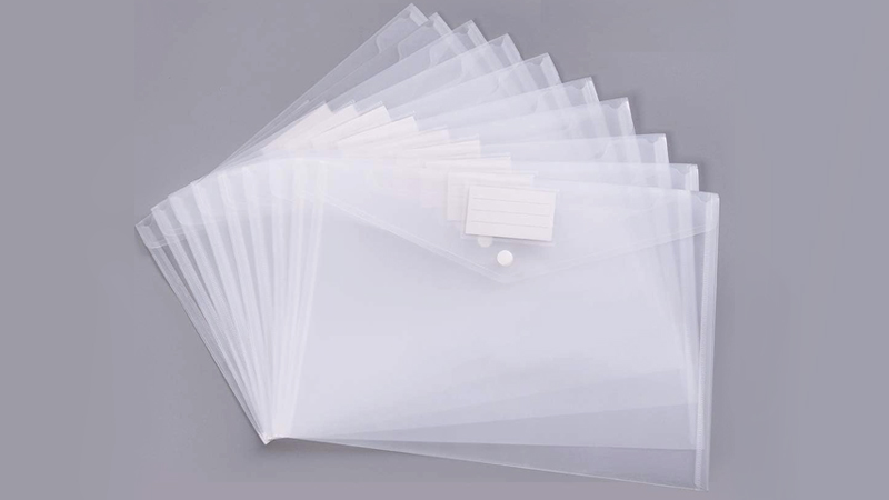 A stack of clear plastic envelopes with snap closures, each featuring a small white label for easy identification. The envelopes are neatly fanned out on a gray surface.
