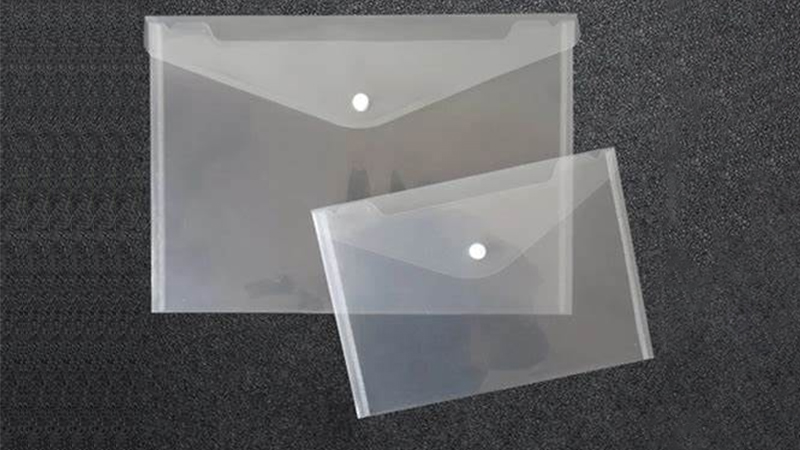 Two clear plastic envelopes of different sizes placed on a black background, showcasing their transparent material and size variation for organizing documents or papers.